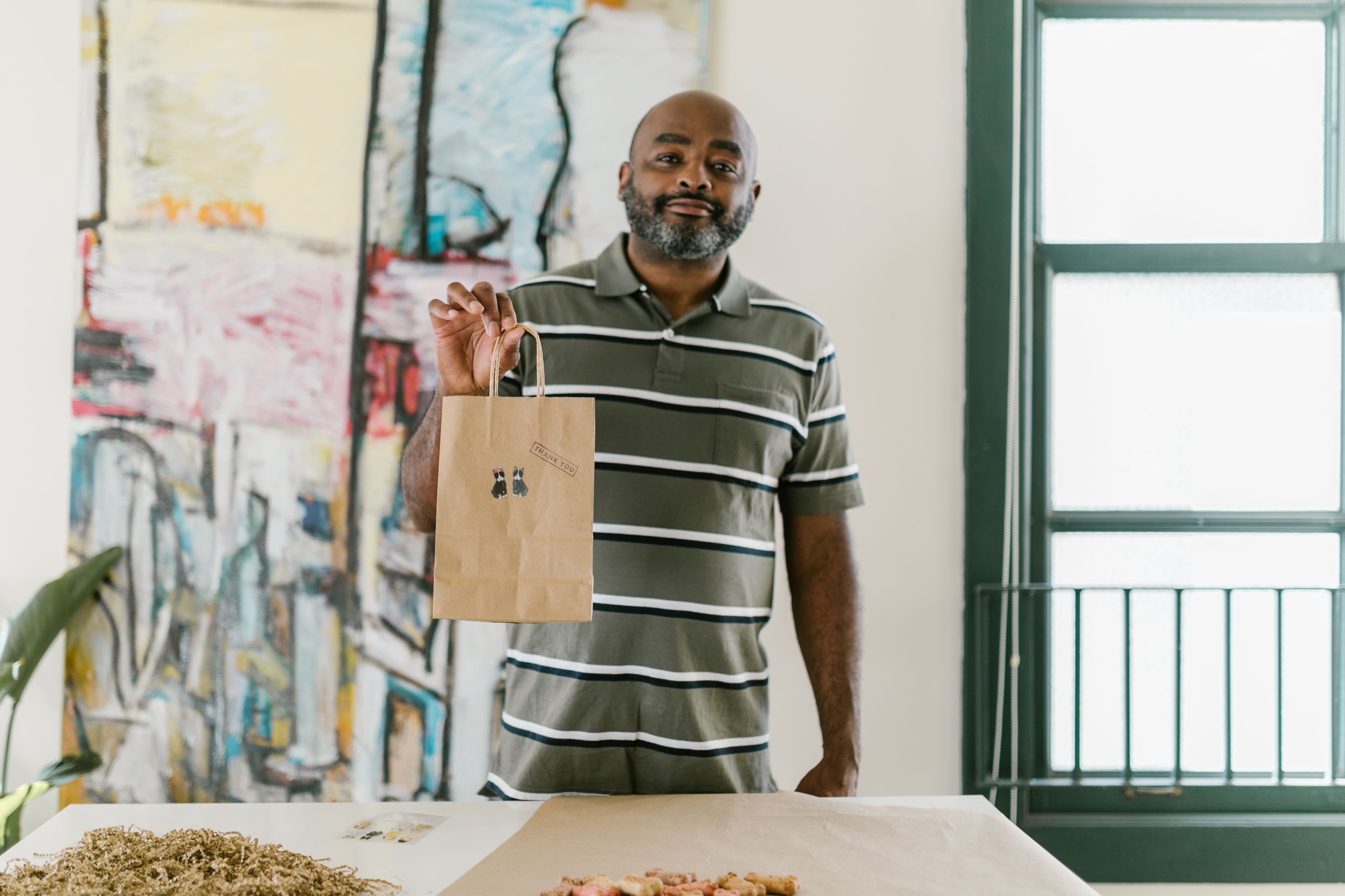A shop owner holding a packed order ready to send